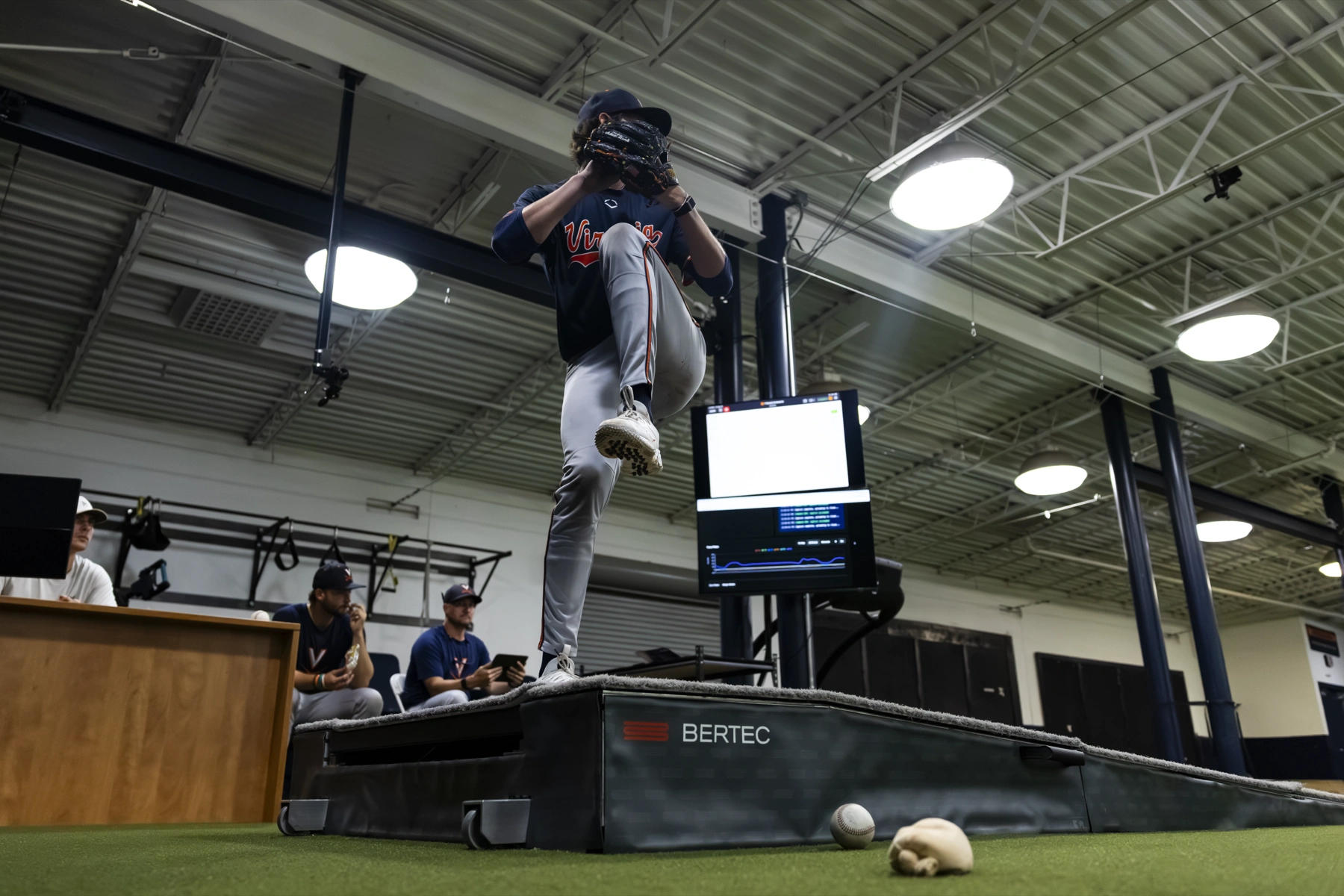 Virginia staff watching a pitcher on the force-plate mound in the Charlottesville lab